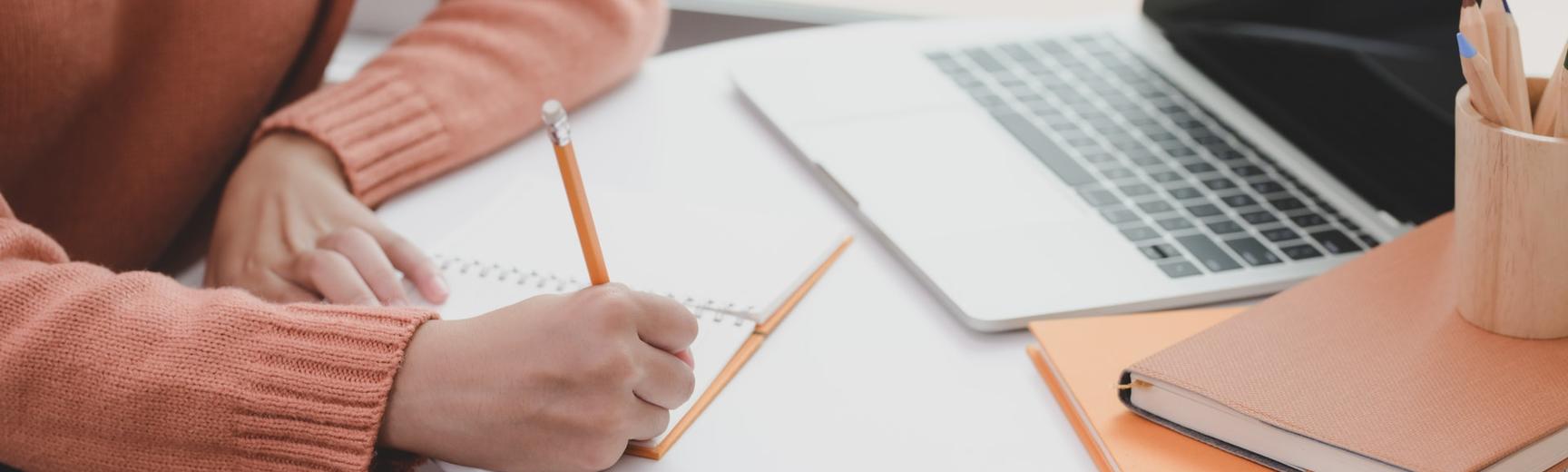 person writing at a desk